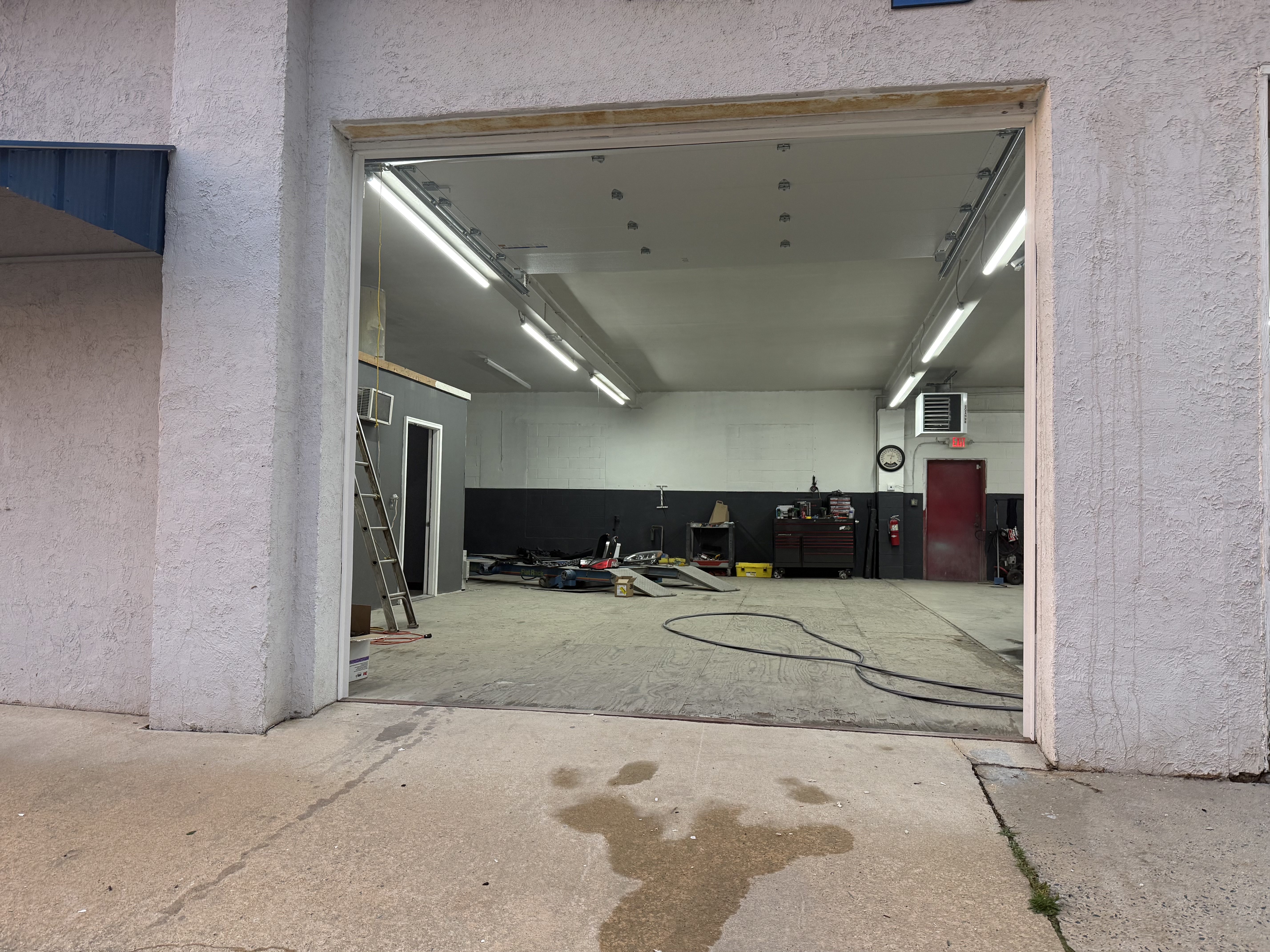 Clean interior work bay with LED lighting and paint booth door
